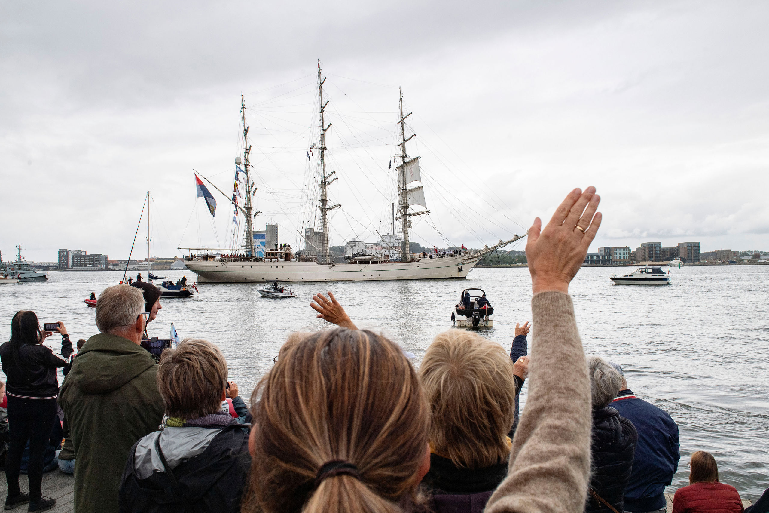 Personer der vinker farvel til skibe