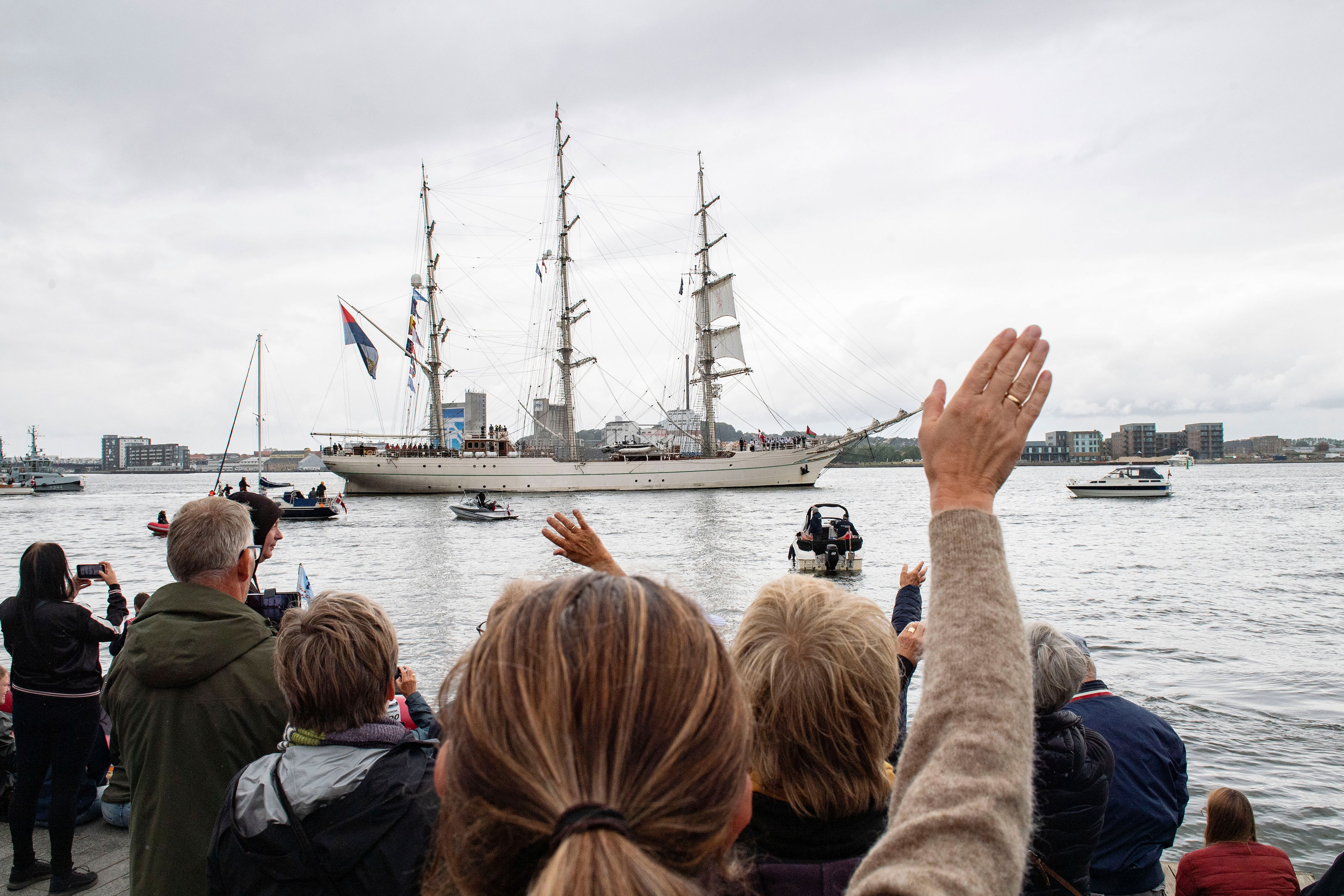 Personer der vinker farvel til skibe
